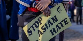Demonstran membawa karton bertuliskan hentikan kebencian terhadap orang Asia. (Foto dari DW.com)