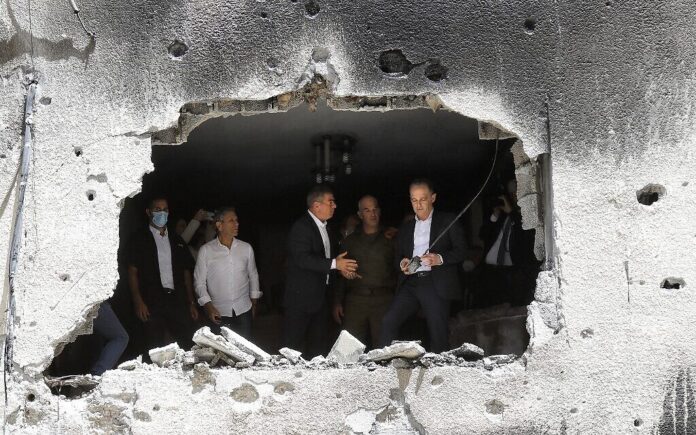 Menteri Luar Negeri Jerman Heiko Maas dan mitranya dari Israel Gabi Ashkenazi (tengah) mengunjungi sebuah gedung yang terkena tembakan roket Hamas dari Gaza, pada 20 Mei 2021, di Petah Tikva. (Gil COHEN-MAGEN / AFP via Times of Israel)