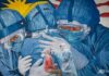 Seorang dokter klinik mengumpulkan sampel untuk pengujian virus corona dari seorang wanita di fasilitas skrining COVID-19 di Klinik Ajwa dekat mural yang menggambarkan garis depan medis di Shah Alam, negara bagian Selangor, Malaysia, pada Sabtu, 12 Desember 2020. (Foto: AP/Vincent Thian/CNA)