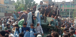 Milisi Taliban dan penduduk setempat terlihat duduk di kendaraan humvee Tentara Nasional Afghanistan (ANA) di sebuah jalan di provinsi Jalalabad pada 15 Agustus 2021. [AFP via Al Jazeera]