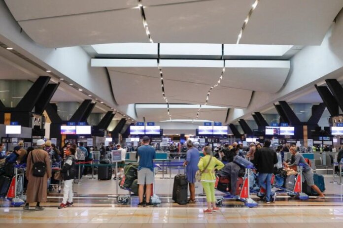 Wisatawan mengantri di konter check-in di Bandara Internasional OR Tambo di Johannesburg, Afrika Selatan, setelah beberapa negara melarang penerbangan dari Afrika Selatan [Phill Magakoe/AFP]