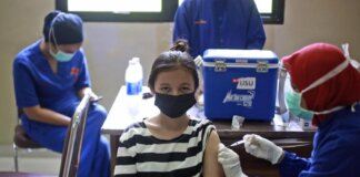 Seorang wanita menerima vaksin Covid-19 di Rumah Sakit Universitas Sumatera Utara di Medan, Sumatera Utara, Indonesia, 26 November 2021. (Foto: AP Photo/Binsar Bakkara via hrw.org)