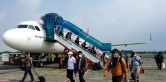 Penumpang yang mengenakan masker tiba di Bandara Halim Perdanakusuma, Jakarta, 20 Oktober 2021 [Willy Kurniawan/ Reuters via Al Jazeera]