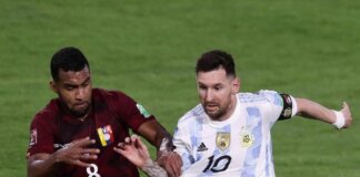Pemain Argentina Lionel Messi (kanan) dan pemain Venezuela Yangel Herrera berebut bola pada pertandingan sepak bola kualifikasi Piala Dunia 2022 di Stadion La Bombonera, Buenos Aires, Argentina, 25 Maret 2022. Argentina menang 3-0. (ALEJANDRO PAGNI/AFP)