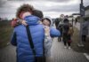 Seorang pria Ukraina memeluk cucu dan putrinya setelah mereka melintasi perbatasan dari Shehyni di Ukraina ke Medyka di Polandia. Ribuan orang melarikan diri dari perang saat Rusia menginvasi Ukraina. (Foto: Keystone/Michael Kappeler/dpa)