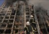 Petugas pemadam kebakaran memanjat tangga saat bekerja untuk memadamkan api di gedung apartemen yang hancur setelah pemboman di daerah perumahan di Kyiv pada hari Selasa. (Foto: Vadim Ghirdă/AP)