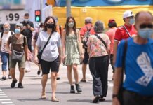 Orang-orang yang memakai masker menyeberang jalan di Chinatown di Singapura pada 22 Februari 2022. (File foto: CNA/Gaya Chandramohan)