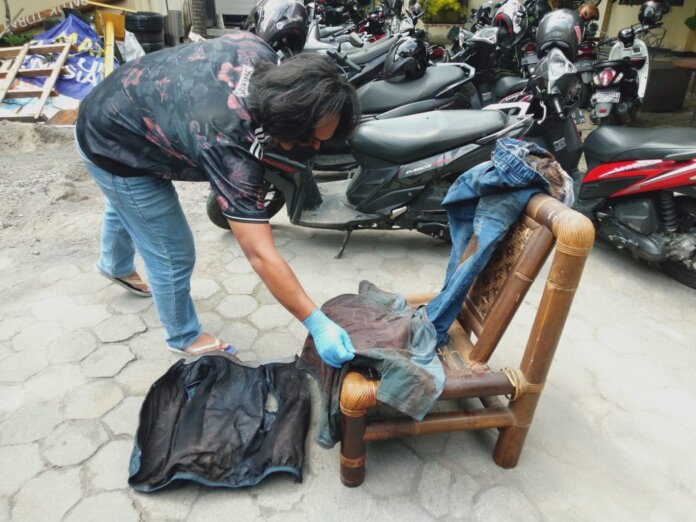 Seorang petugas Kepolisian di Polresta Yogyakarta terlihat sedang mengamankan barang bukti berupa pakayan dari korban yang terlihat berlumuran darah. Foto: Gaga Sallo