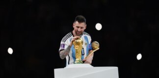 Lionel Messi mengelus trofi Piala Dunia. Foto: Getty Images/Jam Media